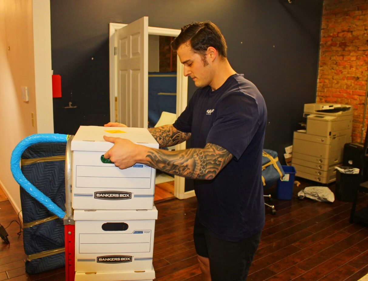 A man stacking boxes in an indoor setting.