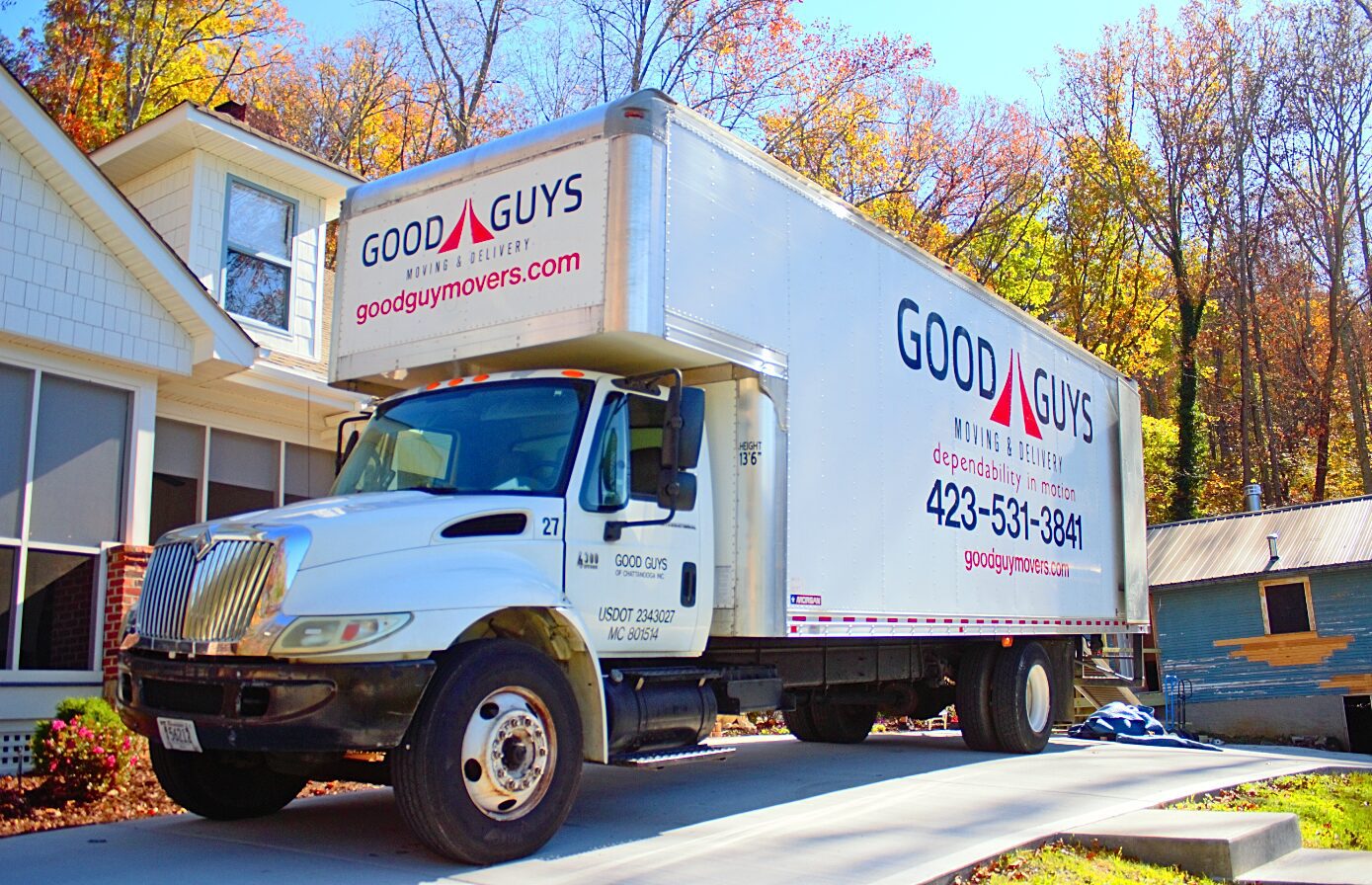 A Good Guys delivery truck parked on a suburban street.