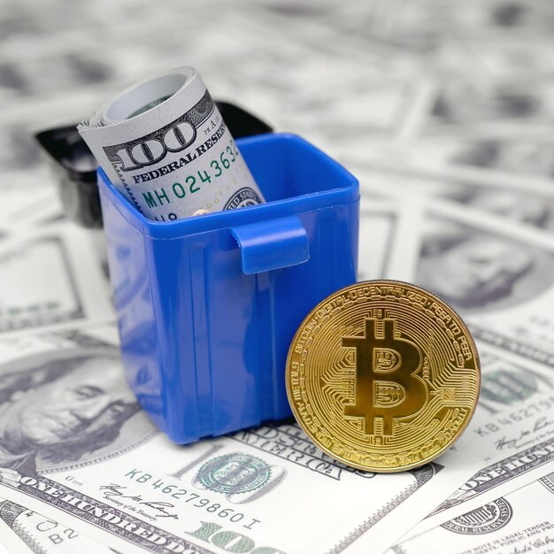 Bitcoin and cash in blue trash bin.